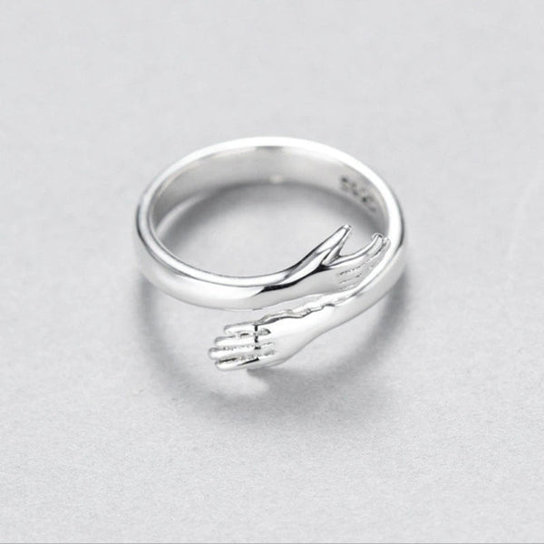 Zilveren ring met omarmend handontwerp, minimalistisch en elegant, perfect als cadeau of accessoire. Handgemaakt sieraad, uniek ontwerp.