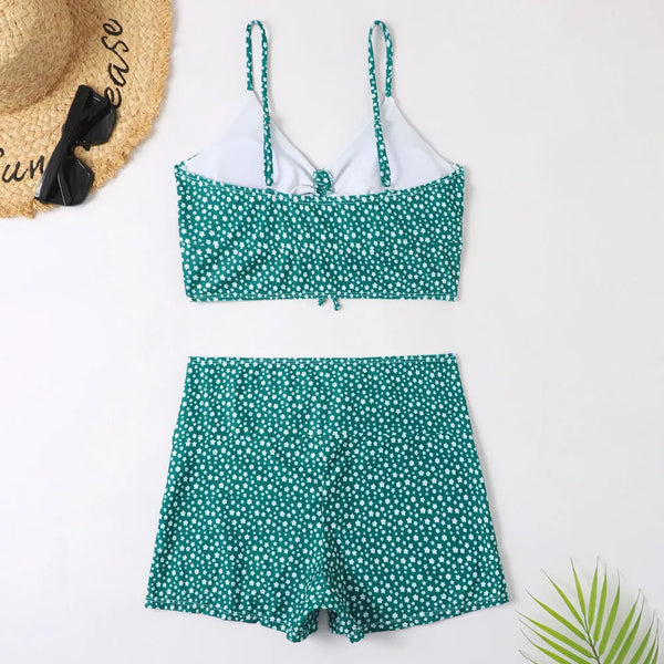 Groene bikini met witte stippen, bestaande uit een top met verstelbare bandjes en een high-waist short. Zomerse accessoires: zonnebril en hoed.