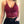 Vrouw in rode kanten crop top met spaghetti bandjes, zwarte broek en riem. Modieuze dameskleding, trendy zomeroutfit, casual stijl.