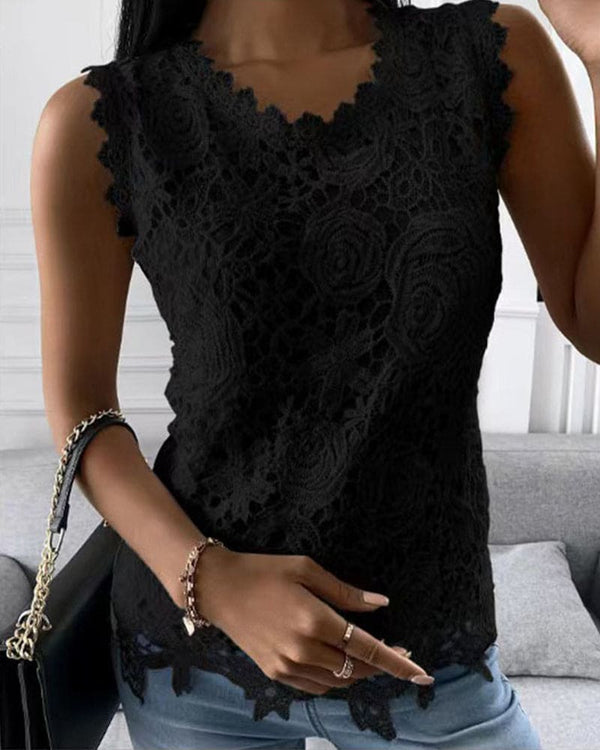 Vrouw in zwarte kanten top met bloemenpatroon, draagt een zwarte handtas en armband. Stijlvolle mode, casual outfit, elegante dameskleding.
