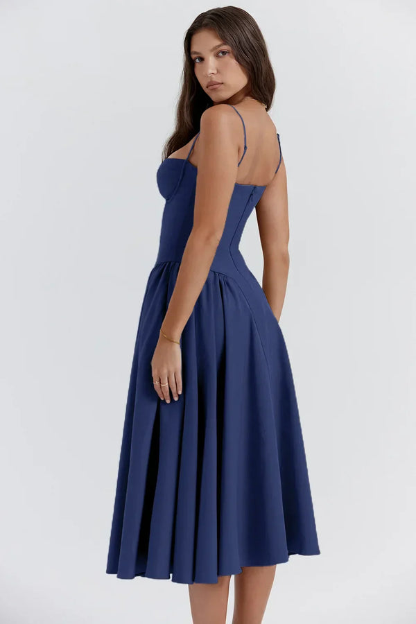 Vrouw in elegante, blauwe midi-jurk met spaghettibandjes, perfect voor zomer- of avondkleding. Stijlvolle mode voor dames, trendy en tijdloos design.