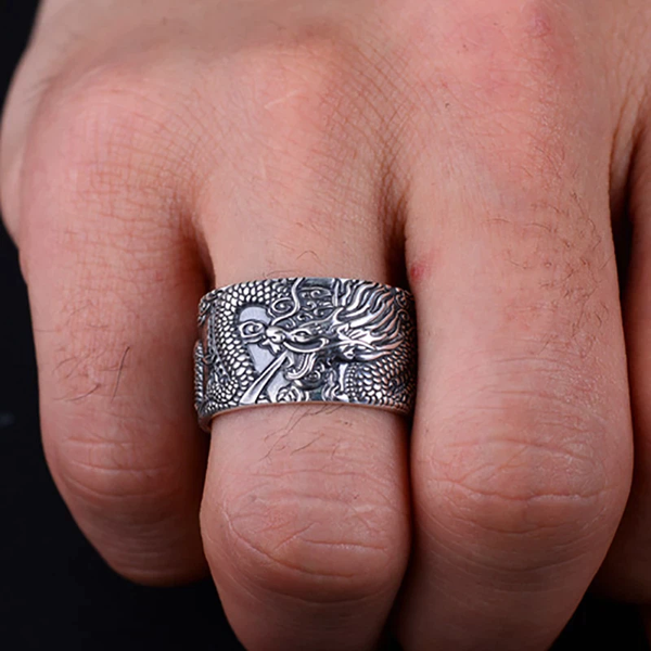 Zilveren drakenring op hand, gedetailleerd gegraveerd, mannenaccessoire, stoere sieraden, unieke stijl, modieuze ring voor dagelijks gebruik.