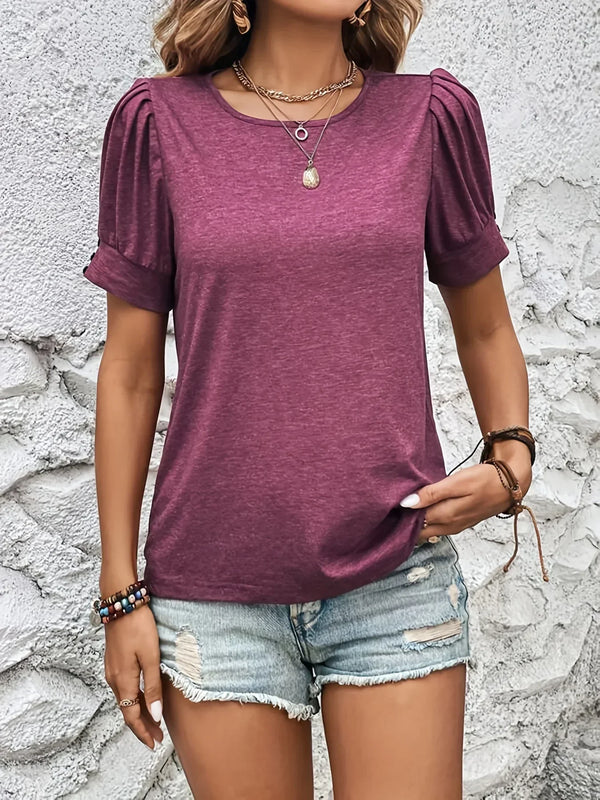 Paarse dames T-shirt met pofmouwen, gedragen met lichtblauwe denim shorts. Trendy zomeroutfit, casual stijl, modieuze sieraden.