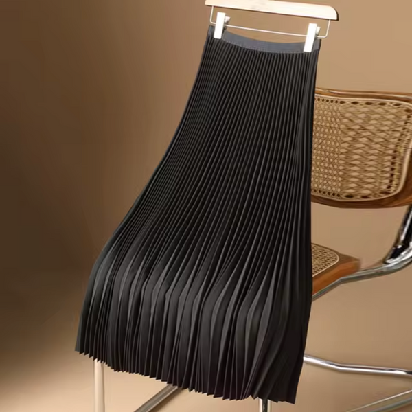 Zwarte geplooide rok op houten stoel, modieuze dameskleding, elegant design, perfect voor casual en formele gelegenheden, trendy modeaccessoire.