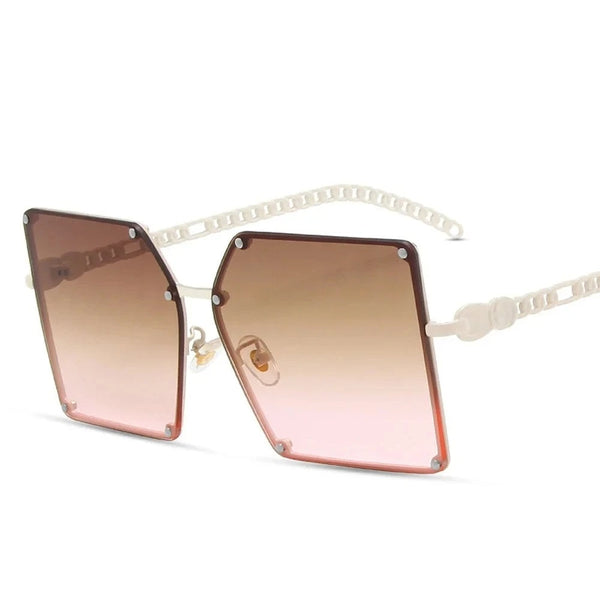 Grote vierkante zonnebril met roze getinte glazen en witte montuur. Modieuze damesaccessoire, UV-bescherming, trendy design.
