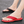 Rode en zwarte teenslippers op asfalt, comfortabele zomerschoenen voor heren en dames, ideaal voor strand en casual gebruik.