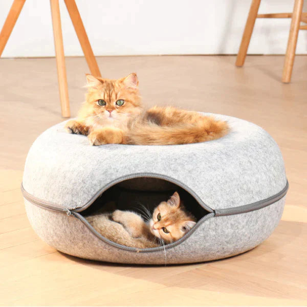 Twee katten in een grijze kattenmand; een ligt bovenop, de ander binnenin. Perfect voor huisdieren, comfortabel en stijlvol kattenbed.