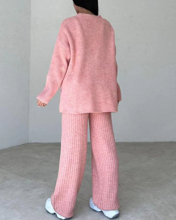 Roze gebreide dames lounge set, bestaande uit een oversized trui en wijde broek, ideaal voor comfortabele en stijlvolle thuisoutfits.