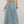 Vrouw in lange denim rok met elastische tailleband en witte sneakers, casual mode, trendy dameskleding, streetwear stijl.