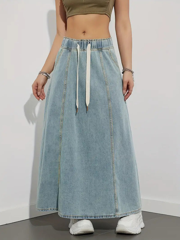 Vrouw in lange denim rok met elastische tailleband en witte sneakers, casual mode, trendy dameskleding, streetwear stijl.