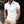 Man in witte polo met zwarte kraag en knopen, beige broek, horloge. Stijlvolle herenkleding, casual mode, stedelijke achtergrond.