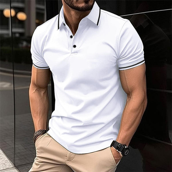 Man in witte polo met zwarte kraag en knopen, beige broek, horloge. Stijlvolle herenkleding, casual mode, stedelijke achtergrond.
