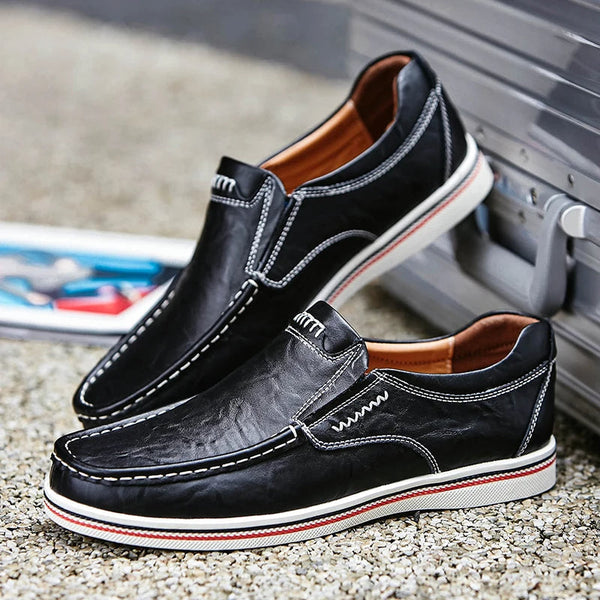 Zwarte leren herenschoenen met witte stiksels en rode accenten, casual en stijlvol, perfect voor dagelijks gebruik. Comfortabele instappers.