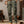 Man in groene cargobroek en bruine trui, draagt bruine laarzen en handschoenen, casual herenkleding, modetrends, comfortabele outdoorstijl.