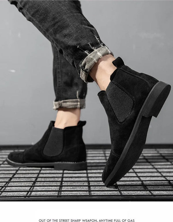 Zwarte suède Chelsea boots voor heren, gedragen met opgerolde jeans. Stijlvolle enkellaarzen, casual mode, comfortabele pasvorm.