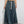 Vrouw in lange denim rok met elastische tailleband en witte trekkoorden, gecombineerd met witte sneakers. Trendy casual damesmode.