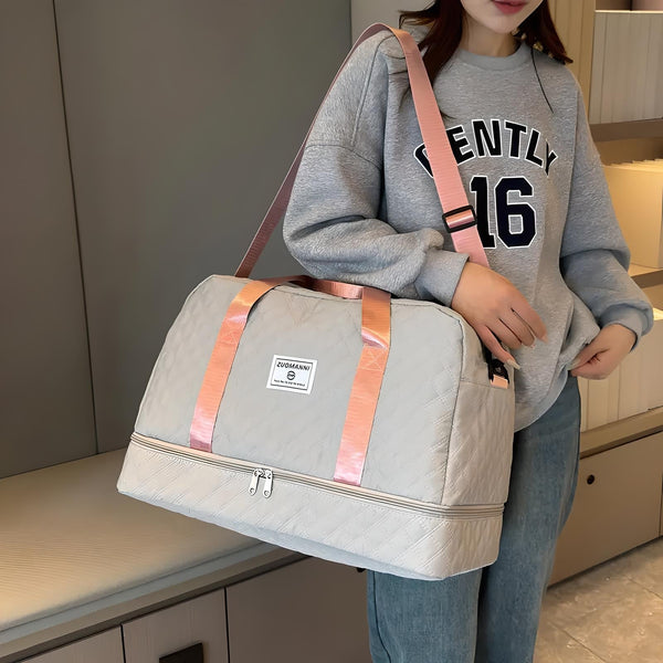 Vrouw met grijze sporttas met roze handvatten, draagt casual outfit. Ideaal voor reizen of sportschool. Trendy en functioneel ontwerp.