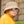 Man met beige teddy bucket hat en reflecterende zonnebril, draagt een gele jas. Stijlvolle wintermode, trendy accessoires, casual outdoor look.