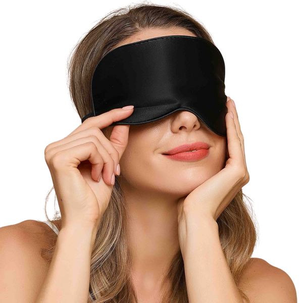 Vrouw met zwarte zijden slaapmasker, ontspanning, slaapaccessoire, luxe slaapmasker, comfortabele pasvorm, stressvermindering, slaapkwaliteit verbeteren.