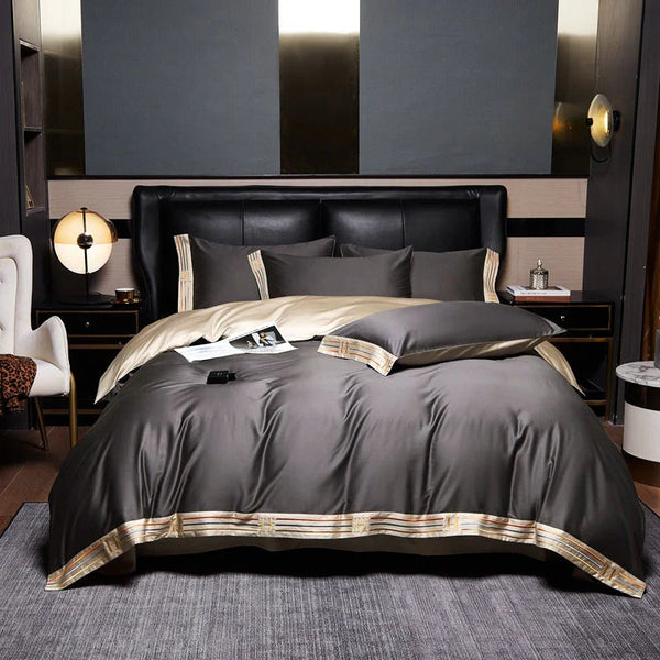 Luxe slaapkamer met grijs en goud dekbedovertrek, leren hoofdbord, moderne lampen en stijlvolle inrichting. Perfect voor elegante slaapkamerinspiratie.