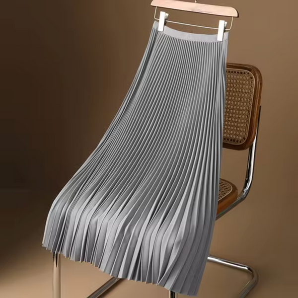 Grijze geplooide rok op houten hanger, hangend aan een retro stoel. Modieuze damesrok, elegant design, perfect voor casual en formele outfits.