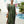 Vrouw in groene kaftan jurk bij zwembad, zomermode, boho stijl, vakantie outfit, rieten tas, tropische achtergrond, ontspannen sfeer.
