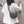 Vrouw met witte trui en groene schoudertas, rug naar camera, casual mode, minimalistisch design, trendy accessoires, stedelijke stijl.