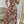 Vrouw in lange, off-shoulder jurk met rood en bruin slangenprintpatroon, poseert voor spiegel. Trendy mode, elegante avondjurk, stijlvolle outfit.