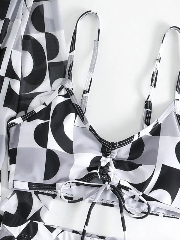 Zwart-wit geometrische bikini met abstracte patronen, verstelbare bandjes en striksluiting. Moderne badmode, trendy zomerstijl.