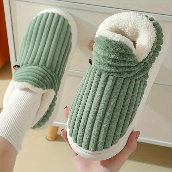 Groene pluche pantoffels met geribbeld ontwerp en witte voering, comfortabel en warm, perfect voor thuisgebruik. Ideaal voor koude winterdagen.