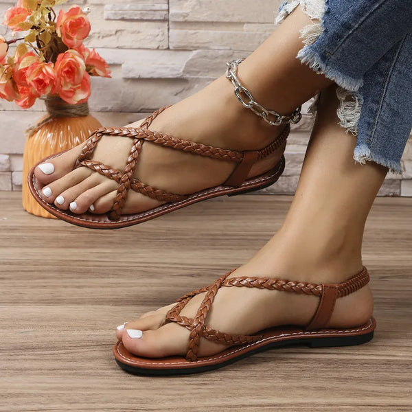 Bruine gevlochten sandalen voor dames, gedragen met jeans. Perfect voor zomermode en casual outfits. Comfortabele en stijlvolle open schoenen.