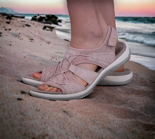 Roze sandalen op strand, comfortabele zomerschoenen voor dames, ideaal voor wandelen langs de kust bij zonsondergang.