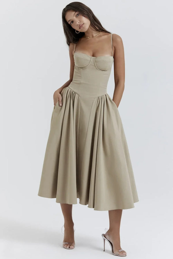 Vrouw in beige midi-jurk met spaghettibandjes en geplooide rok, elegante avondkleding, modetrend 2023, stijlvolle damesmode.