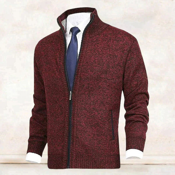 Donkerrode gebreide herenvest met ritssluiting, witte overhemd en blauwe stropdas. Stijlvolle herenkleding, geschikt voor zakelijke en casual gelegenheden.