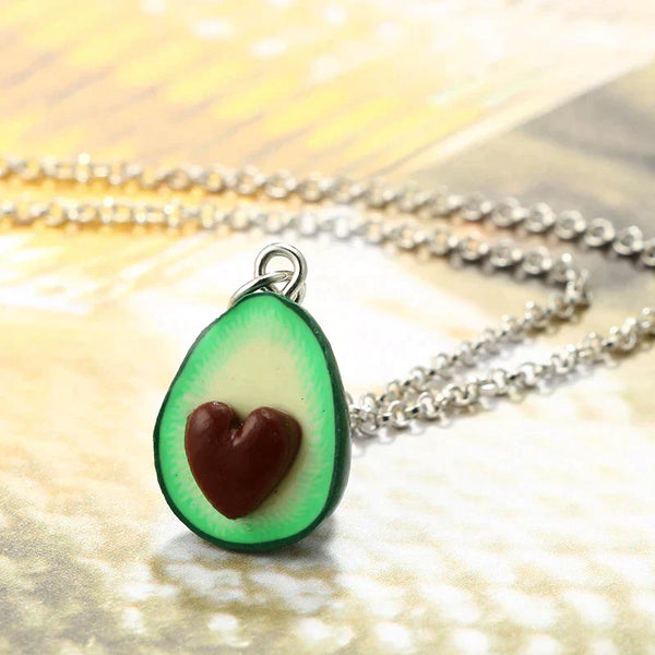 Avocado kettinghanger met hartvormige pit, zilveren ketting, trendy sieradenaccessoire, perfect cadeau voor avocado liefhebbers.