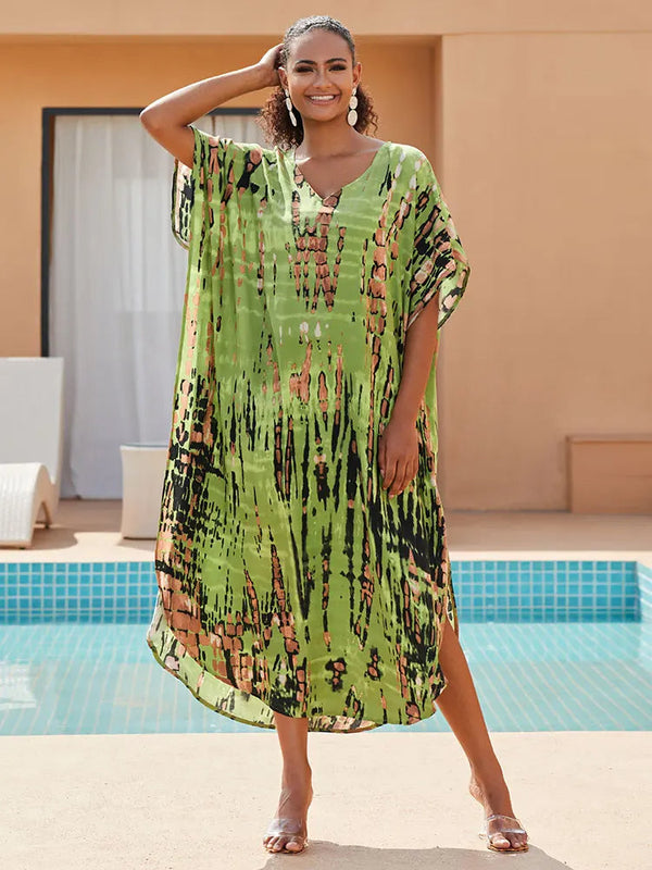 Vrouw in groene kaftan met abstract patroon, poseert bij zwembad. Zomermode, comfortabele strandkleding, trendy damesjurk.