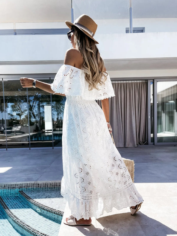 Vrouw in witte kanten zomerjurk en strohoed bij zwembad, moderne villa op achtergrond. Zomermode, vakantie, strandkleding, elegantie.