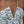 Vrouw in zomerjurk met blauwe bloemenprint en halternek, close-up. Perfect voor strandmode en zomerse stijl. Elegante en luchtige uitstraling.