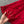 Rode kanten stof met bloemmotief, hand houdt delicate textuur vast. Perfect voor elegante jurken, bruidsmode en feestelijke kleding.