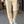 Beige damesbroek met scherpe vouw, gedragen met witte sneakers. Modieuze casual outfit, ideaal voor dagelijks gebruik en stedelijke stijl.
