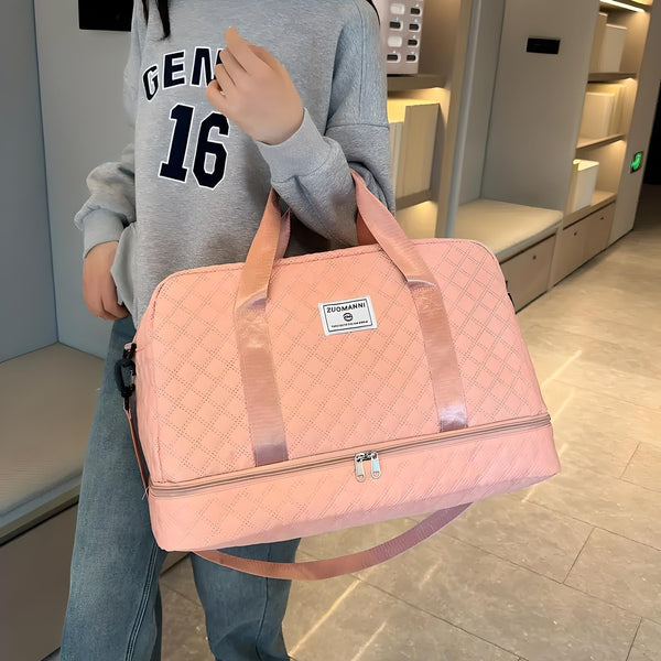 Vrouw met grijze trui en jeans houdt een roze, gewatteerde sporttas vast in moderne gang. Tas met ritssluiting en merklabel.