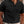 Man in zwarte polo met korte mouwen en ribbeltextuur, gecombineerd met witte broek. Stijlvolle herenkleding, casual en modern design.