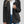 Vrouw draagt zwarte teddyjas, witte trui en blauwe jeans. Stijlvolle wintermode, warme damesjas, casual outfit. Perfect voor koude dagen.