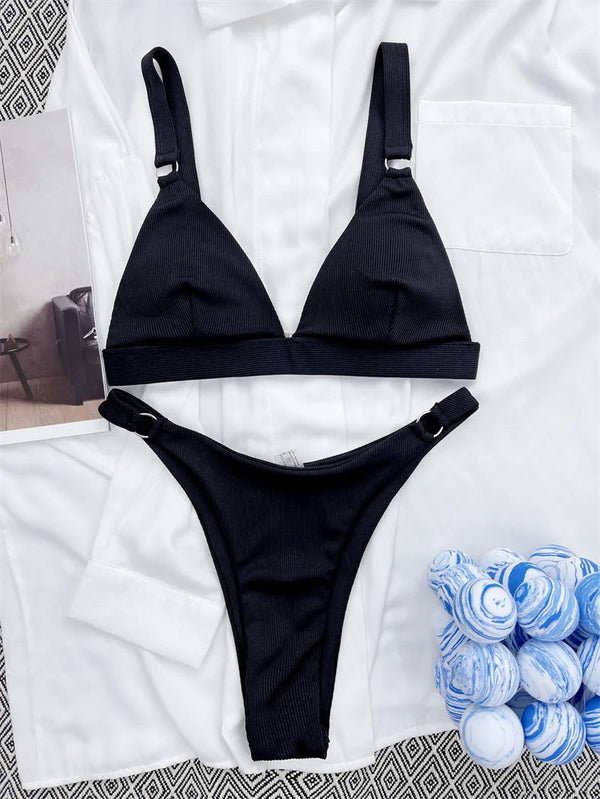 Zwarte ribgebreide bikini set op witte achtergrond, bestaande uit een triangel bikinitop en een hoog uitgesneden slip. Perfect voor strandmode en zomertrends.