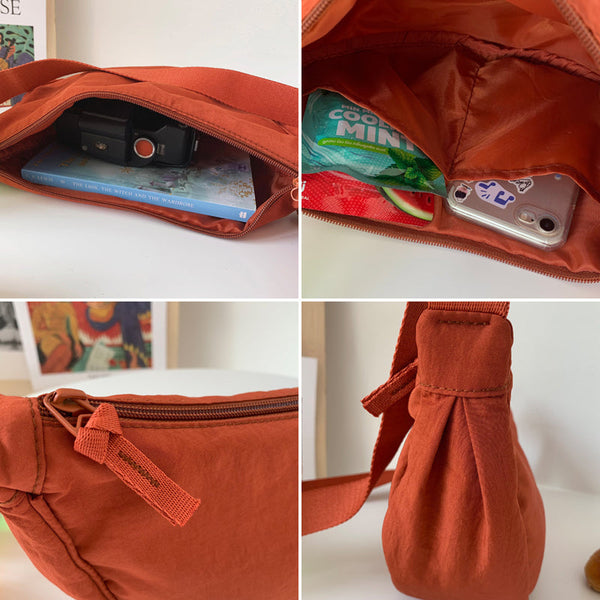 Oranje heuptas met rits, gevuld met camera, boek, muntkauwgom en smartphone. Ideaal voor reizen en dagelijks gebruik. Compact en stijlvol ontwerp.