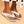 Witte orthopedische slippers voor dames, comfortabel en stijlvol, met perforaties en decoratieve details, ideaal voor zomerse outfits en dagelijks gebruik.