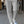 Grijze, stijlvolle damesbroek met scherpe vouw, gedragen met witte sneakers. Perfect voor casual en zakelijke outfits. Mode, dameskleding, trendy.