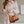 Vrouw in geruite jurk met bruine leren schoudertas. Modieuze damesaccessoires, casual stijl, trendy handtas, elegante outfitcombinatie.