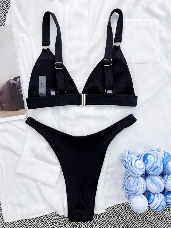 Zwarte ribgebreide bikini met verstelbare bandjes en metalen sluiting, liggend op witte achtergrond. Perfecte strandkleding voor dames.