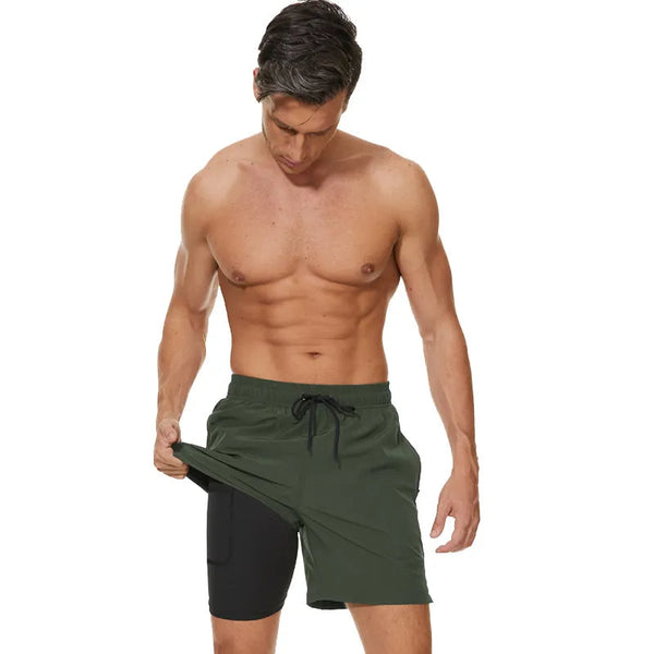 Man in groene sportshorts met zwarte binnenvoering, toont zak. Fitnesskleding, sportmode, comfortabele trainingsshorts voor heren.